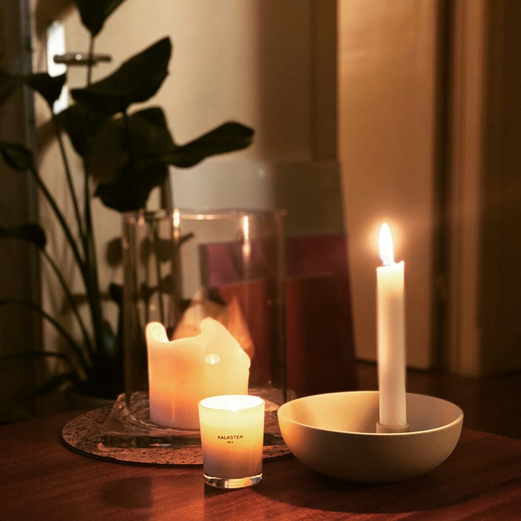 Candle fire safety reminder showing lit candles on a table in a cosy home setting.